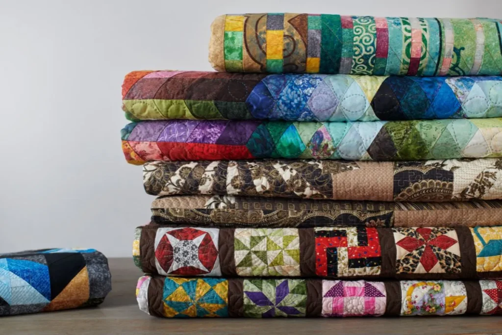 stack of colorful folded quilts.