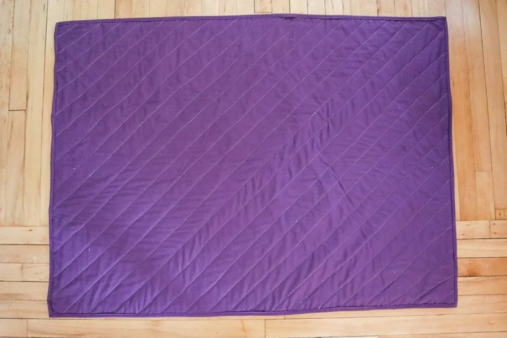 a quilt laying face down on the ground.