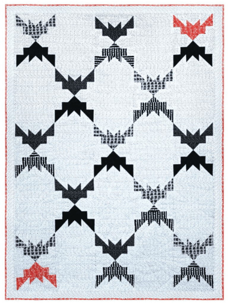A quilt with black grey and orange bats with a white background.