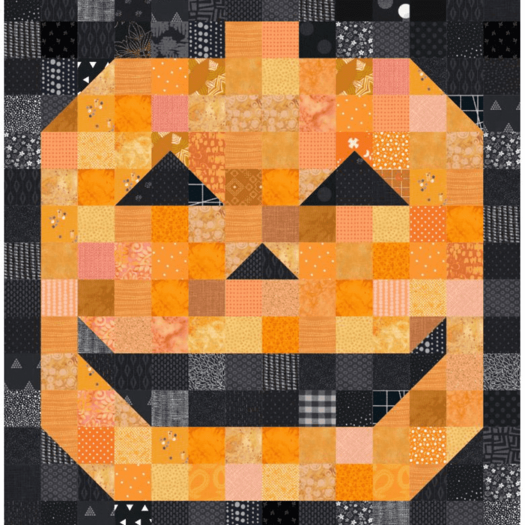A black and orange jack-o-lantern quilt.