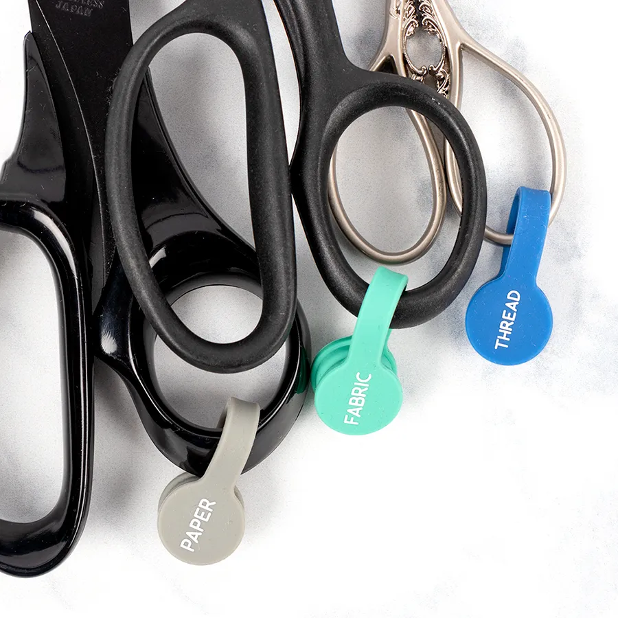 Three pairs of scissors with labels saying paper, fabric, and thread respectively.